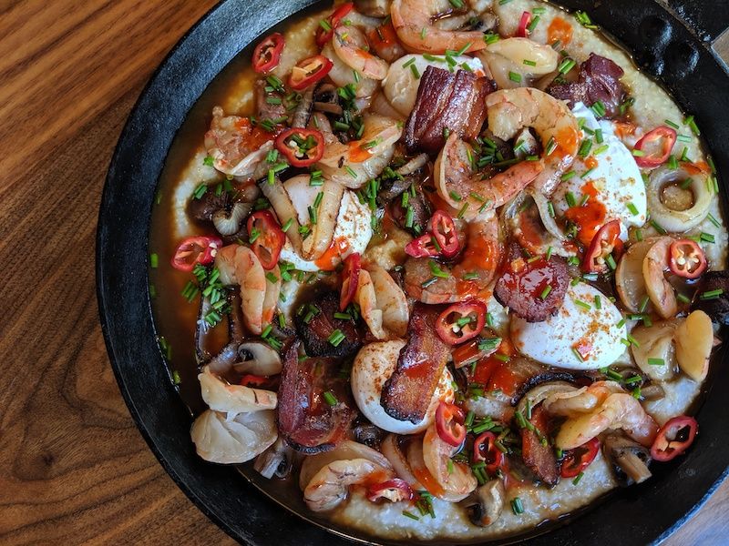 Low country–inspired shrimp and grits (with bacon lardons, roasted mushrooms, sweet onions, and scallions).