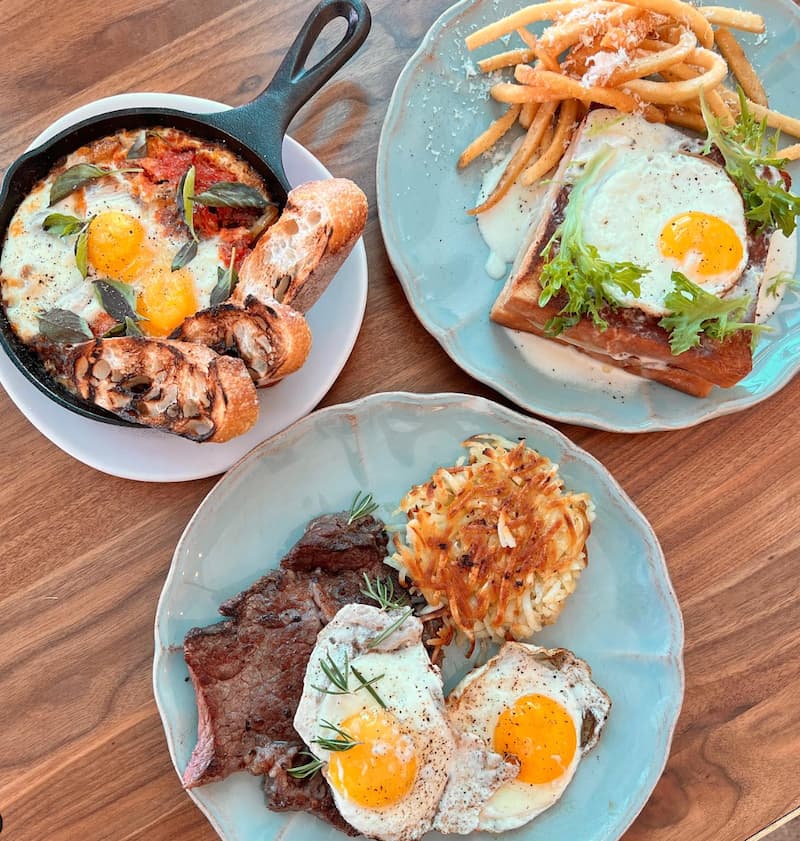 A selection of new French bistro brunch dishes at Cassava with eggs on bread, steak, and in shakshuka