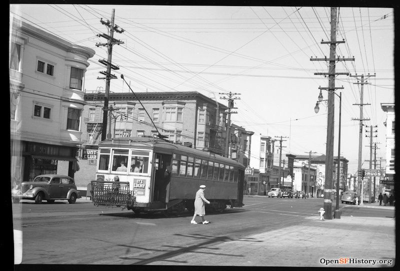You can see the sign for the Hunt-In Club on the left behind the streetcar which a woman is walking in front of
