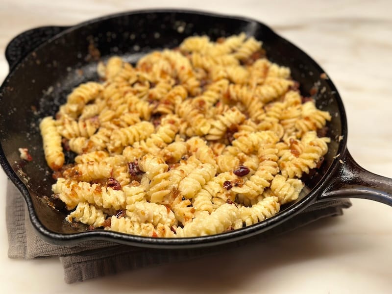 Southern kugel with ricotta, chowchow, pecan, and sage brown butter in a cast-iron pan