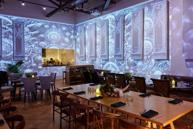 The dining room features immersive mapping projections on the walls. Photo: Hardy Wilson.