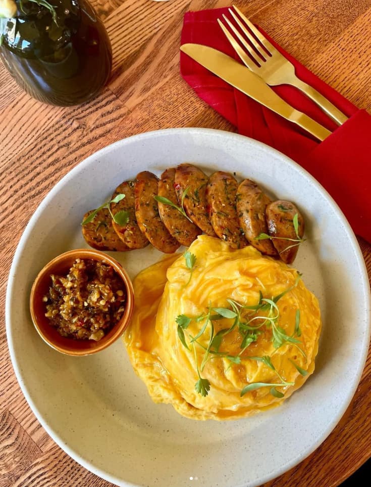 Housemade sai oua (a Chiang Mai–style sausage) with lava eggs and nam prik noom at Tanzie’s Cafe. Instagram photo via @tanziescafe.